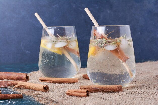 Limones con una taza de bebida en azul.