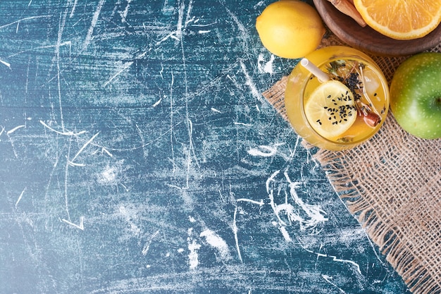 Limones con una taza de bebida en azul.