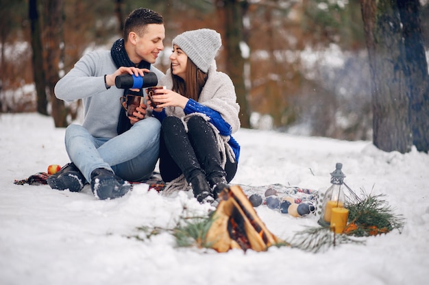 Linda y amorosa pareja en un bosque de invierno