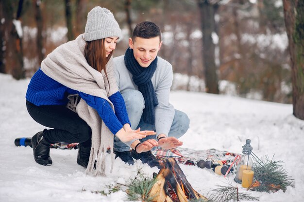 Linda y amorosa pareja en un bosque de invierno