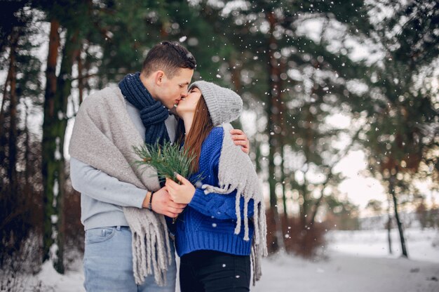 Linda y amorosa pareja en un bosque de invierno