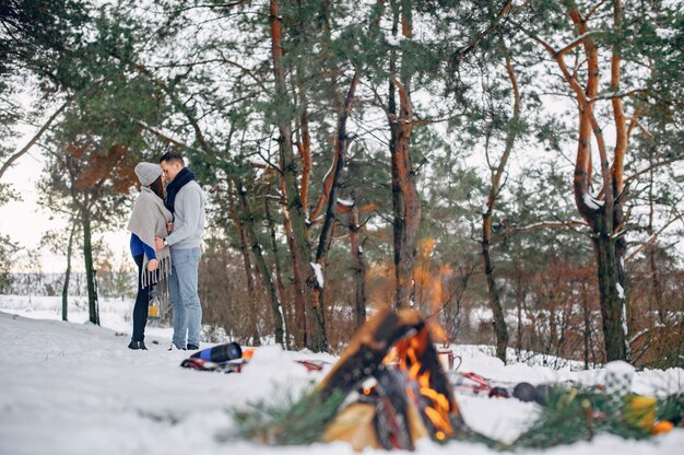 Linda y amorosa pareja en un bosque de invierno