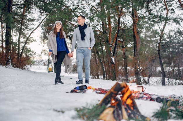 Linda y amorosa pareja en un bosque de invierno