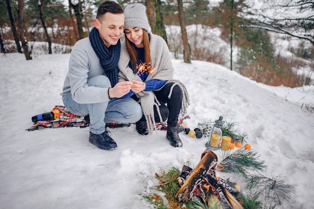 Linda y amorosa pareja en un bosque de invierno