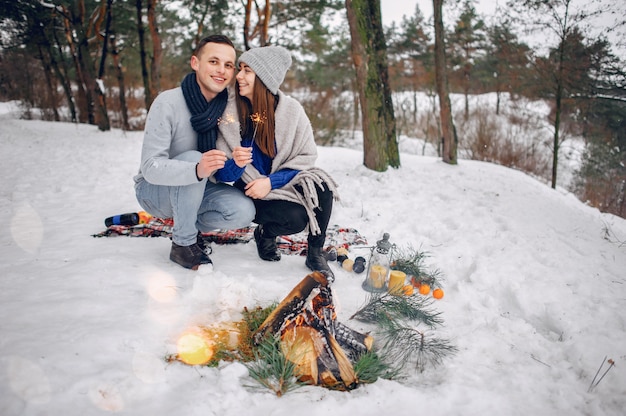 Linda y amorosa pareja en un bosque de invierno