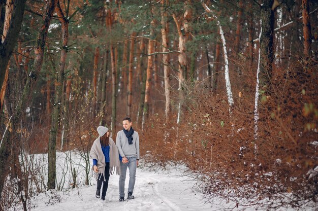 Linda y amorosa pareja en un bosque de invierno