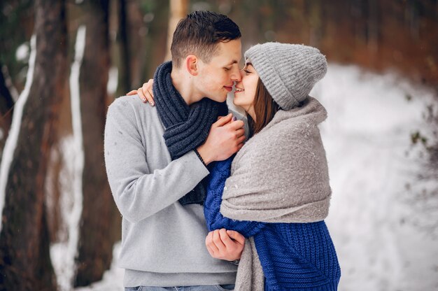 Linda y amorosa pareja en un bosque de invierno