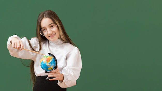 Foto gratuita linda chica apuntando al globo