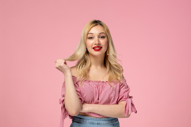 Linda chica bastante rubia con lápiz labial rojo en blusa rosa con mechón de pelo