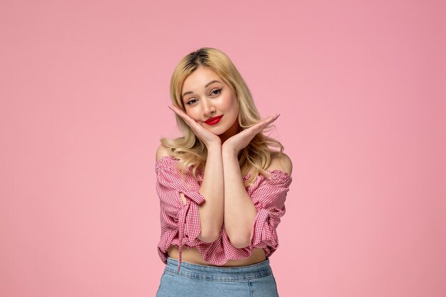 Linda chica bastante rubia con lápiz labial rojo en camisa rosa mirando adorable