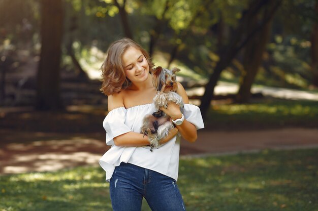 Linda chica en blusa blanca jugando con perrito