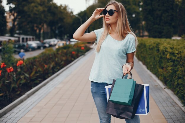 Linda chica con bolsa de compras en una ciudad