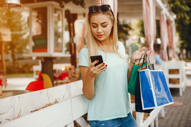 Linda chica con bolsa de compras en una ciudad