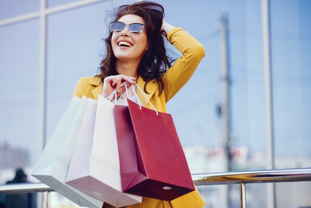 Linda chica con bolsa de compras en una ciudad