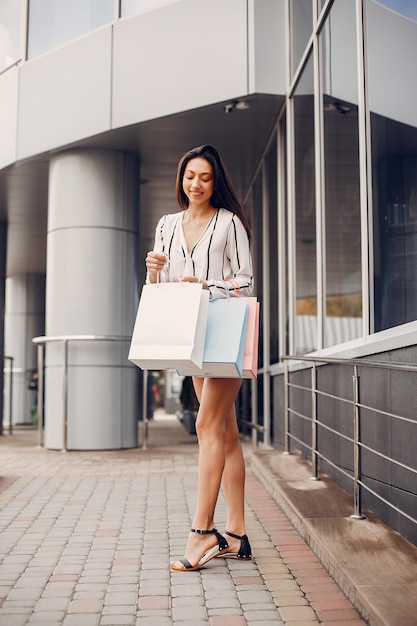 Linda chica con bolsa de compras en una ciudad