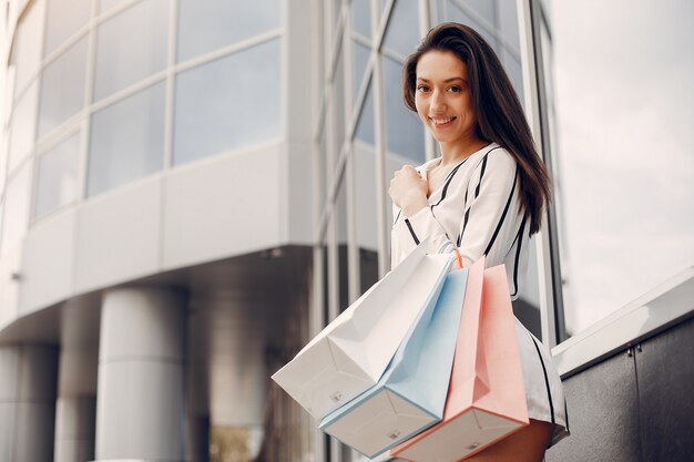 Linda chica con bolsa de compras en una ciudad