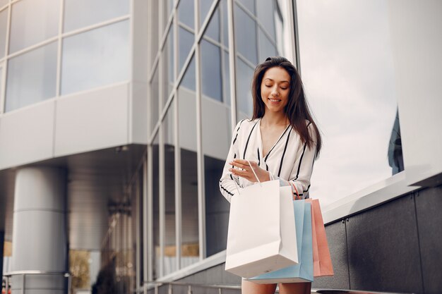 Linda chica con bolsa de compras en una ciudad