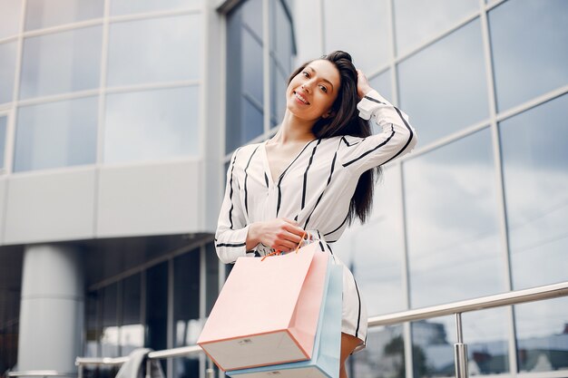 Linda chica con bolsa de compras en una ciudad