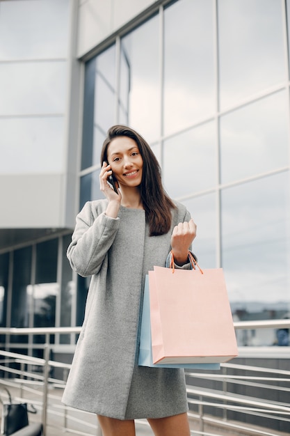 Linda chica con bolsa de compras en una ciudad