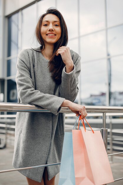 Linda chica con bolsa de compras en una ciudad