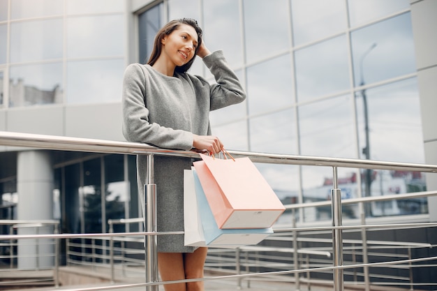 Linda chica con bolsa de compras en una ciudad