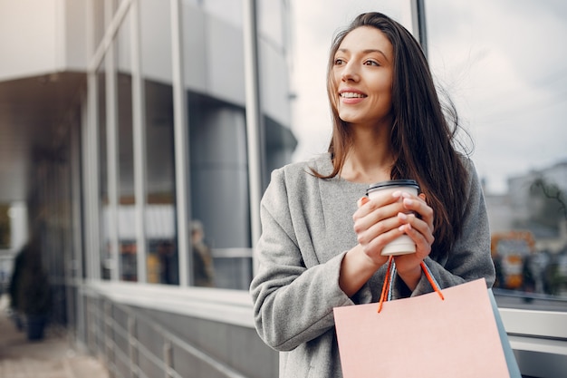 Linda chica con bolsa de compras en una ciudad