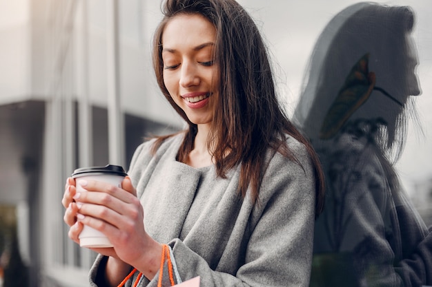 Linda chica con bolsa de compras en una ciudad