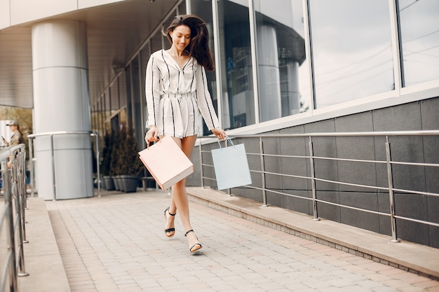 Linda chica con bolsa de compras en una ciudad