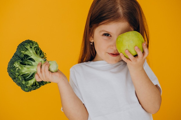 Foto gratuita linda chica con brócoli y manzana