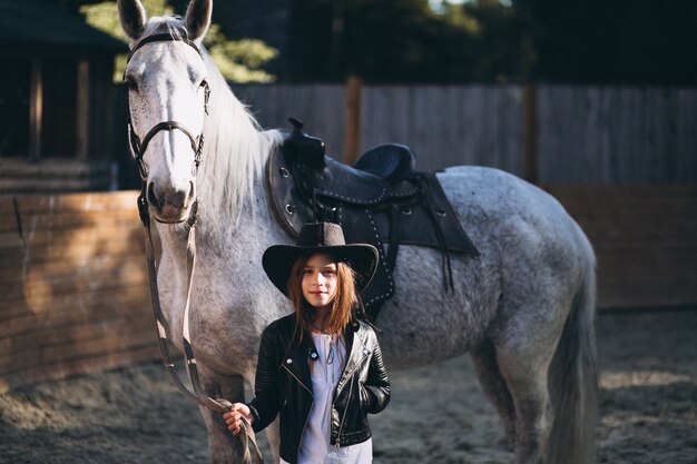 Linda chica con caballo en el rancho