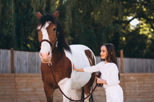 Linda chica con caballo en el rancho