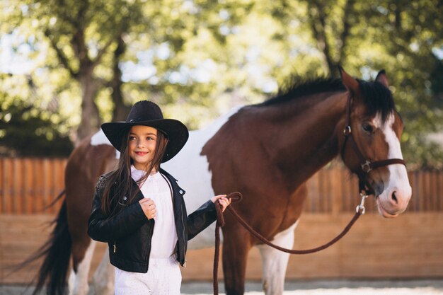 Linda chica con caballo en el rancho
