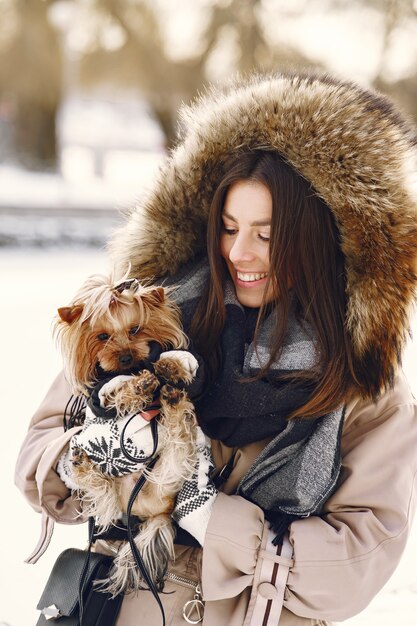 Linda chica caminando en un parque de invierno con su perro