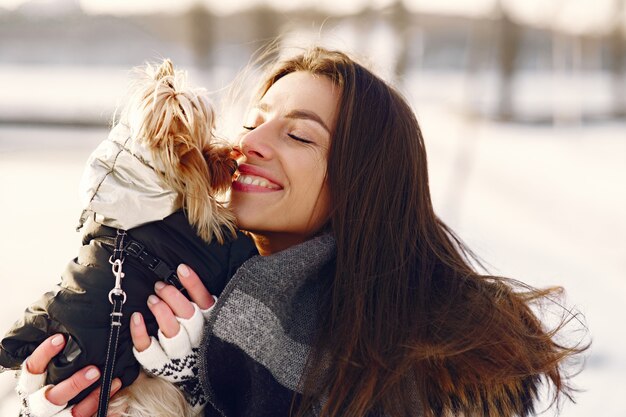 Linda chica caminando en un parque de invierno con su perro