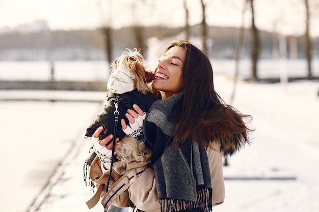 Linda chica caminando en un parque de invierno con su perro