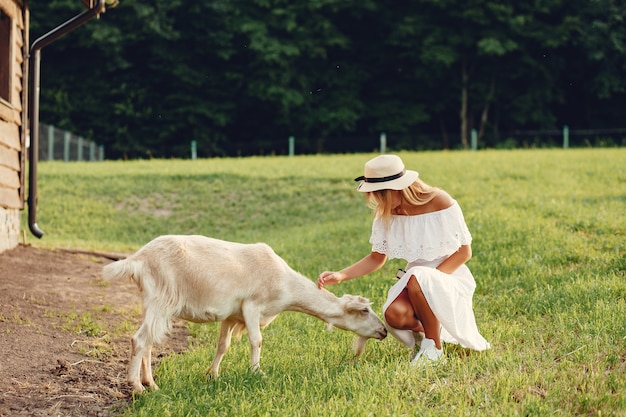 Linda chica en un campo con cabras