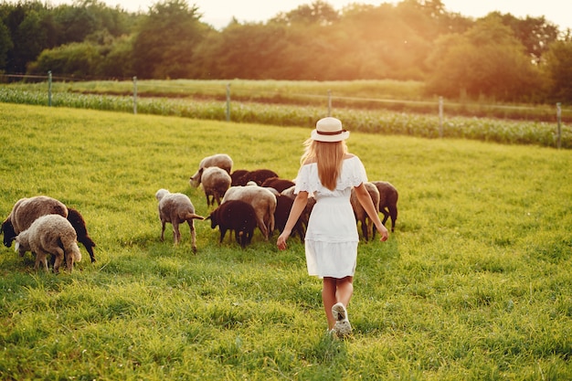 Foto gratuita linda chica en un campo con cabras