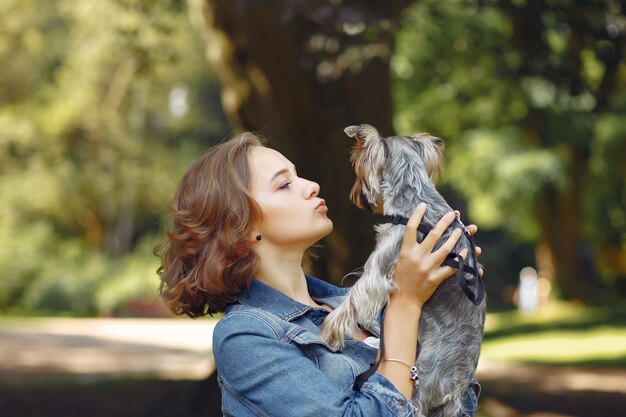 Linda chica en chaqueta azul jugando con perrito