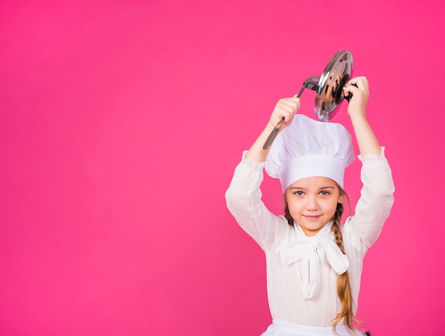 Linda chica cocinar con cucharón y cubrir sonriendo