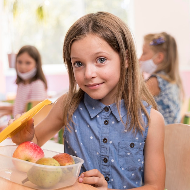 Foto gratuita linda chica comiendo en el concepto de escuela