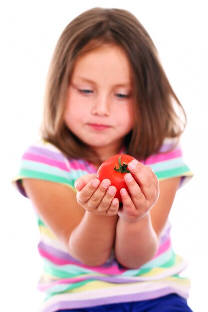 Linda chica comiendo un tomate