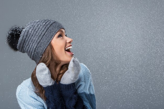 Linda chica con copos de nieve pasando un buen rato