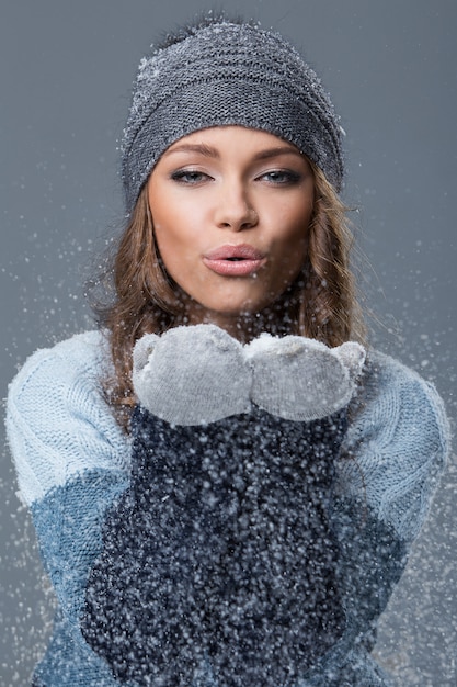 Linda chica con copos de nieve pasando un buen rato