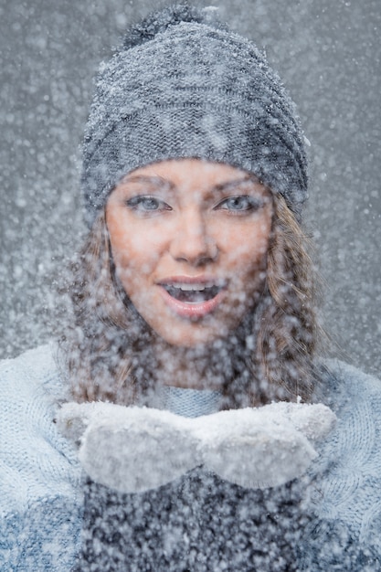 Linda chica con copos de nieve pasando un buen rato