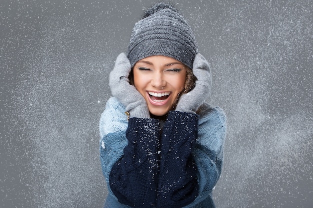 Linda chica con copos de nieve pasando un buen rato