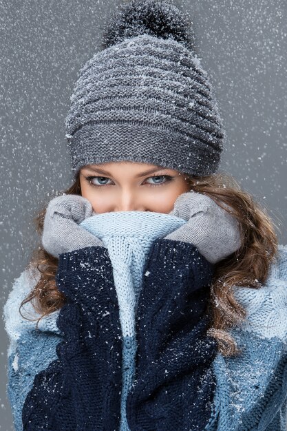 Linda chica con copos de nieve pasando un buen rato