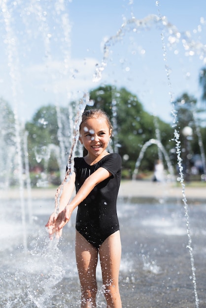 Foto gratuita linda chica divirtiéndose en la fuente de agua