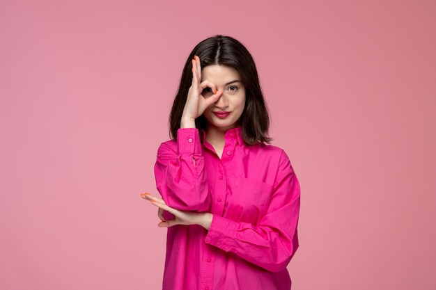 Linda chica encantadora dama adorable con lápiz labial rojo en camisa rosa que cubre un ojo con la mano