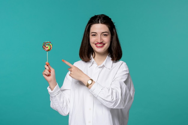 Linda chica encantadora joven guapa morena con camisa blanca muy feliz por lollipop