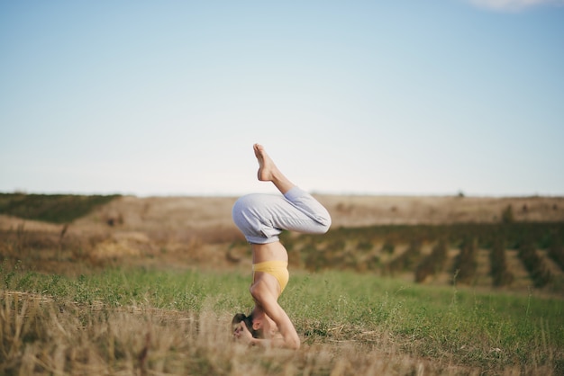 Foto gratuita linda chica entrenando en el cielo azul en un campo